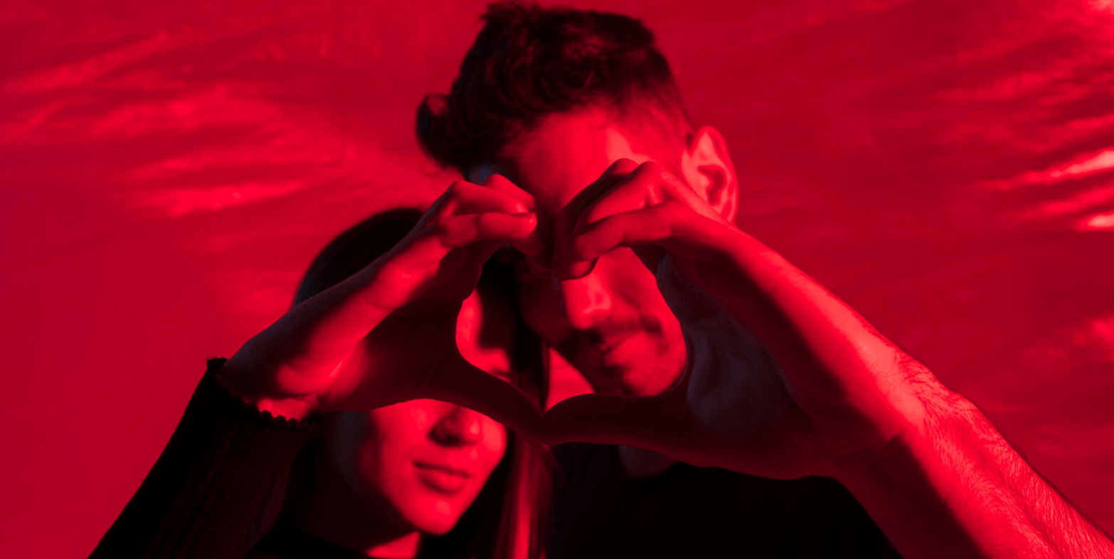 Red-lit couple portrait with a bold Manchester mood